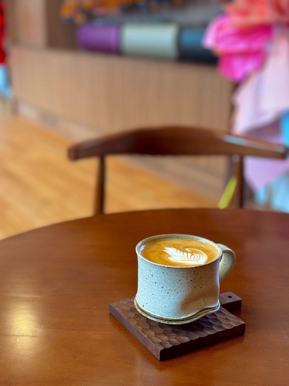 Coffee with latte art on a wooden table at Symphonia Café