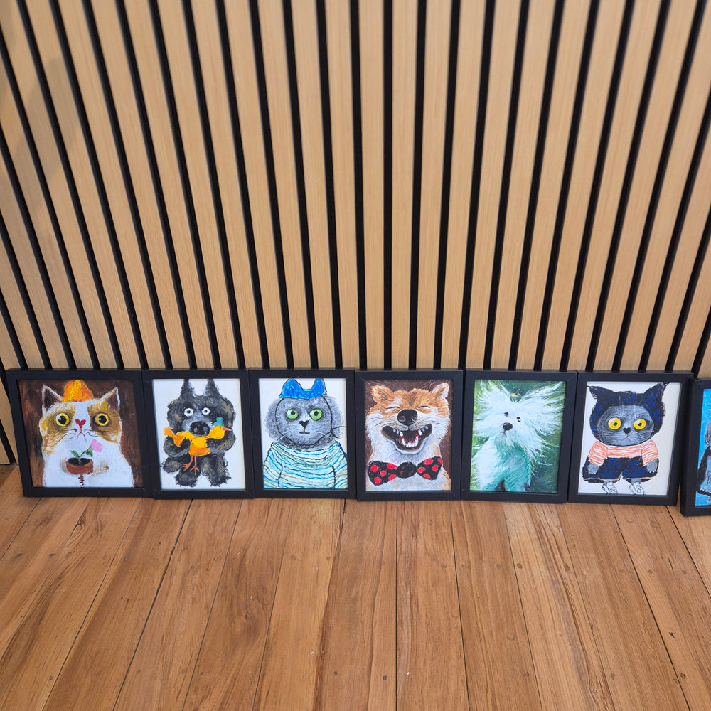 Colourful cat paintings displayed along the wooden wall
