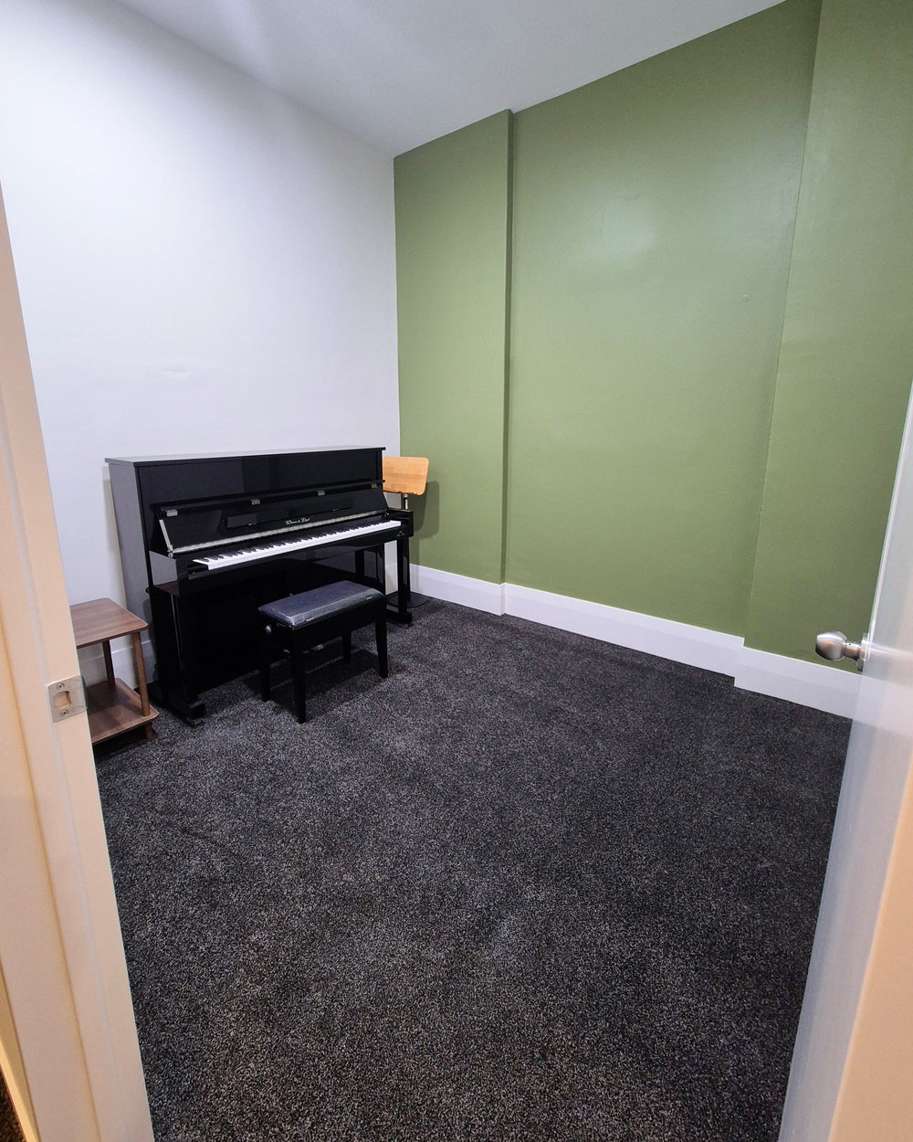 Practice room 4 with a piano beside a green feature wall