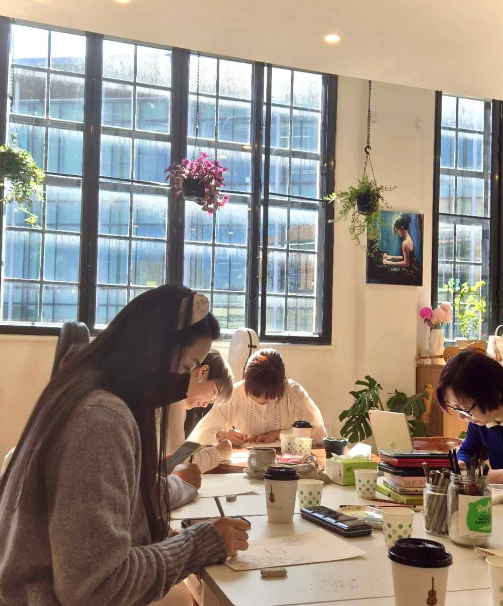Participants painting together at tables in Symphonia Café