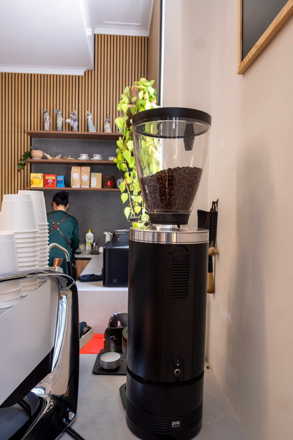 Coffee grinder beside the espresso machine at Symphonia Café
