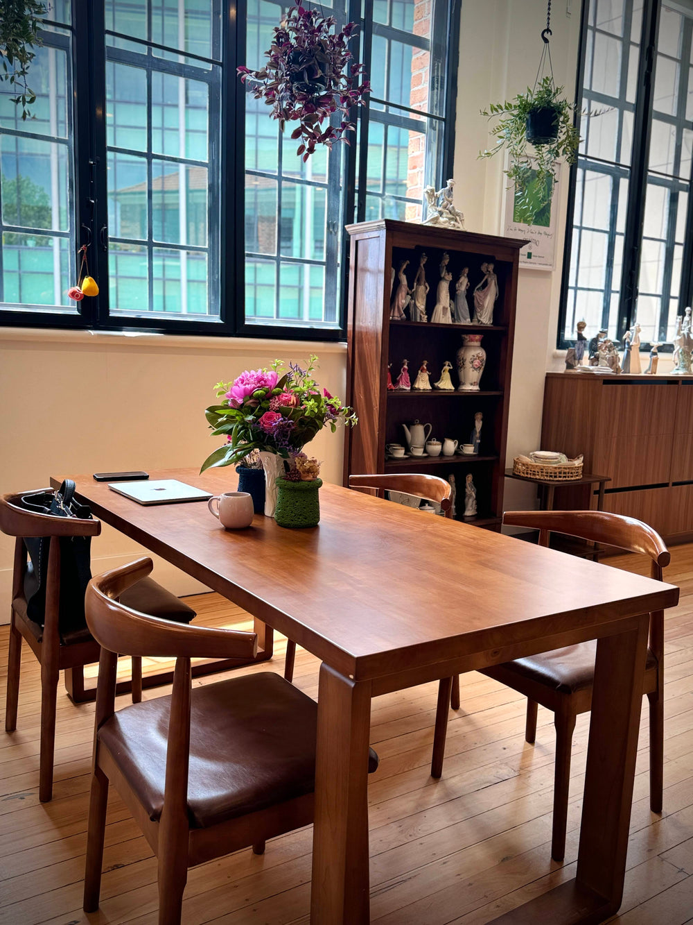 Wooden café table and chairs beside a tall window