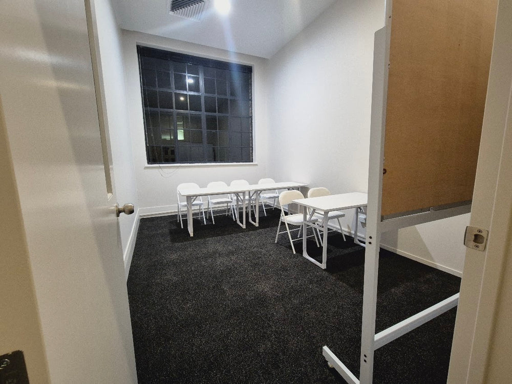 Symphonia Music Room 7 with tables, chairs and a whiteboard