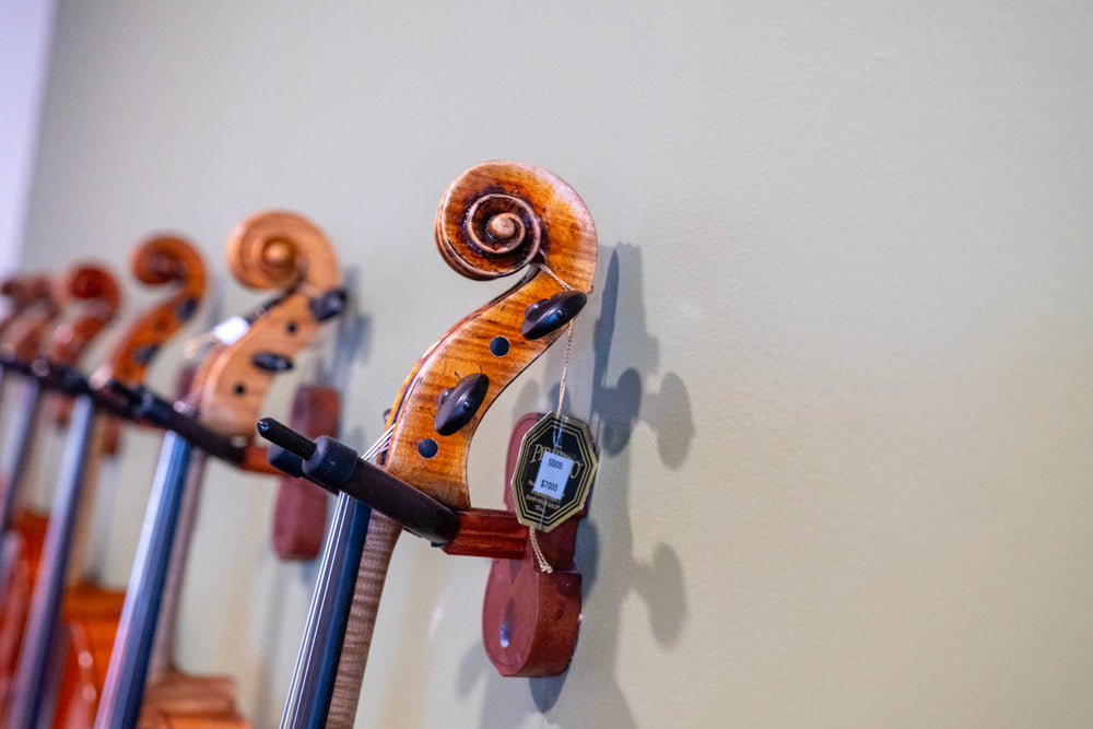 Close-up of cello scrolls in the Symphonia Strings showroom